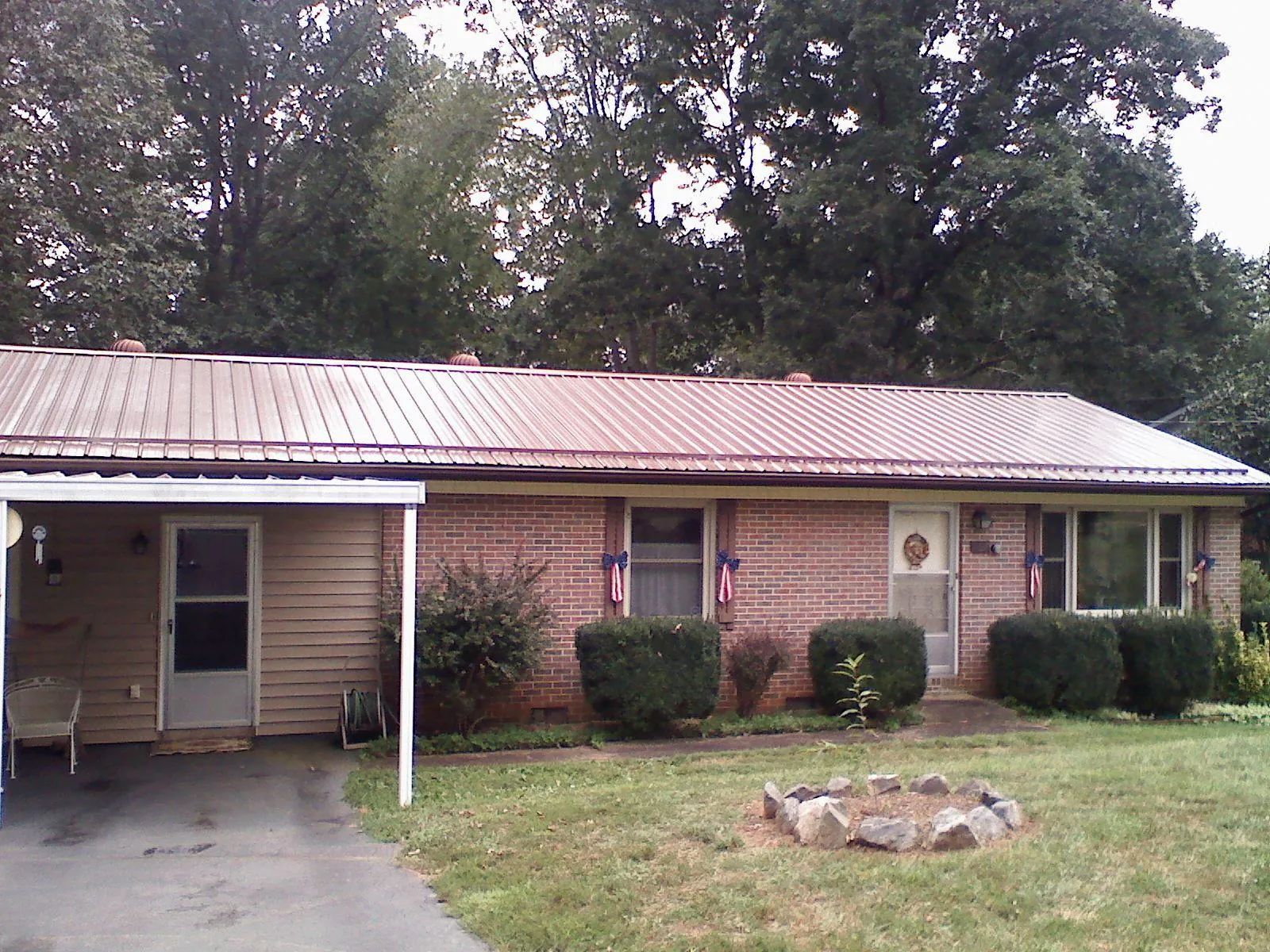Bronze metal roof and carport on a brick ranch home — Roof Repair work by our crew in Mc Allister